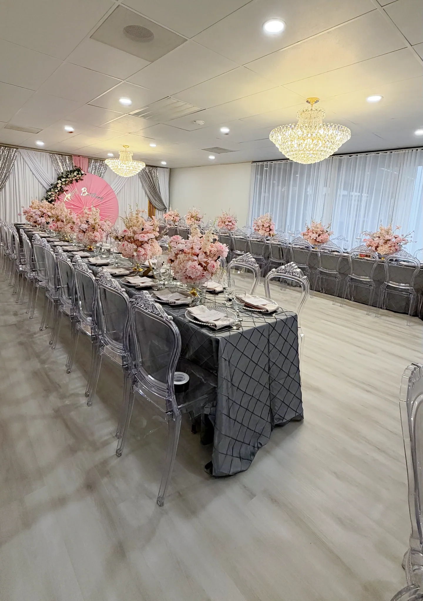 Portrait view along floral dining tables and draped windows in The Victoria.